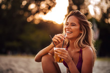 Close-up Portrait Of A Beautiful Happy Young Woman Drinking On A Beach. Summer Vacation Concept.
