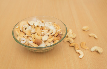 Cashews in the transpatent bowl on the wooden table