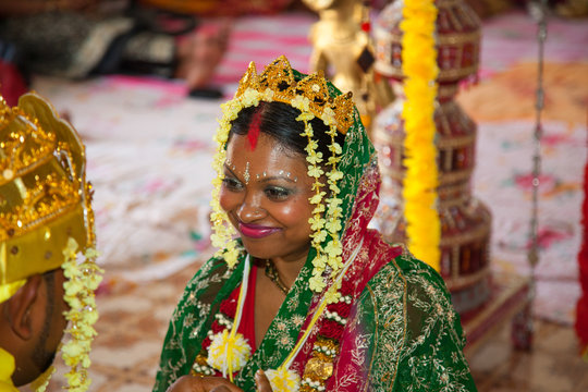 A happy bride smiles at her fiance at a wedding ceremony in a Hindu temple. Indian wedding celebrations and traditions, world tourism.