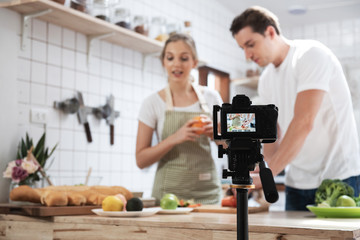 Professional digital mirrorless camera  recording video blog of happy caucasian couple cooking in the kitchen room, Camera for photographer or video and live streaming concept,Vlogger and blogger.