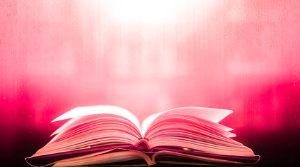 Poster - An ancient book that opens with magic, the magic light in the darkness on the wooden table, by the bright light shining down as the power to search for knowledge, religion and background