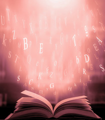 Poster - Open book on the table and English alphabet Floating above the book  in the library and blur bookshelf background