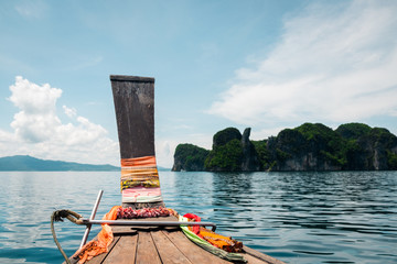 A long tail boat enters a secluded lagoon in Phang Nga Bay, Thailand