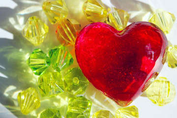  Blurry image of red glass heart and yellow beads. Abstract love background. Hand made, Valentine day, objects concept.