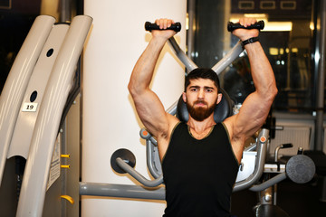 male athlete is engaged in physical training in a sports gym