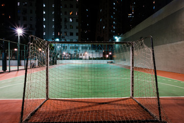 soccer goal on sports field in city at night