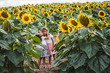 Little girls among of a sunflower among a field of sunflowers in the evening. Summer concept