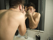 © Ladanifer - Portrait of handsome caucasian teenager reflection in from of the mirror, waxing his eyebrows with tweezers