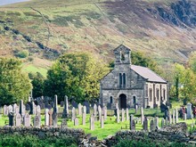 Church With Graveyard In The Country Below Mountain In The Welsh Countryside