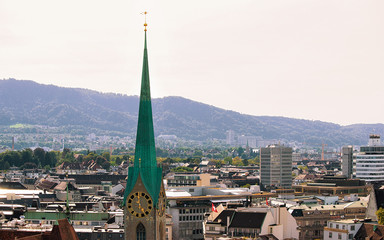 Wall Mural - Spire of Grossmunster Church and rooftops of the city center of Zurich, Switzerland.