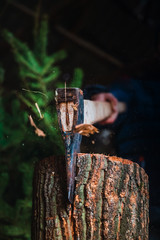 Lumberjack cutting a log with an ax, the pieces of wood are scattered in different directions.