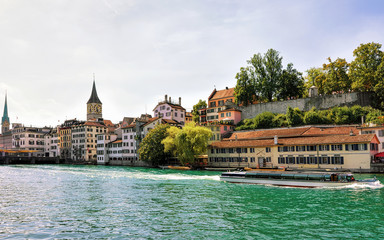 Wall Mural - River cruiser at Limmat quay and St Peter Church and Fraumunster Church in the city center of Zurich, Switzerland.