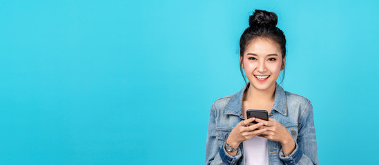 banner of portrait happy asian woman feeling happiness and looking camera holding smartphone on blue