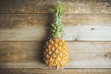 Fresh ripe pineapple on the rustic background. Selective focus.