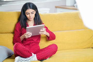 Wall Mural - Persian woman at home using digital tablet