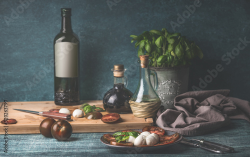 Cuadros en Lienzo Food still life with oil bottles, mozzarella, tomatoes and kitchen herbs in pot