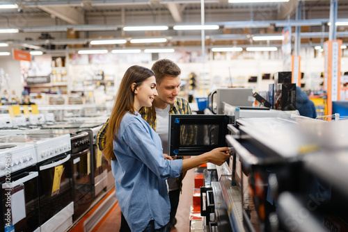 Cuadros en Lienzo Couple choosing microwave in electronics store