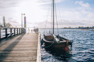 Wall Mural - Sailboat near the shore. Blue sky and water at sunny day. The concept of recreation and travel.