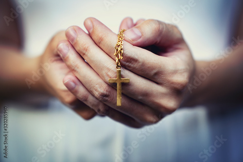 Fotografía woman hands praying holding a beads rosary with Jesus Christ in the cross or Crucifix on black background