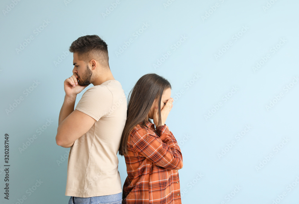 Quarreled young couple on color background