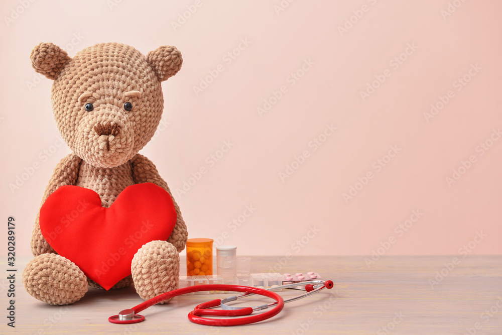 Stethoscope, heart and baby toy on table