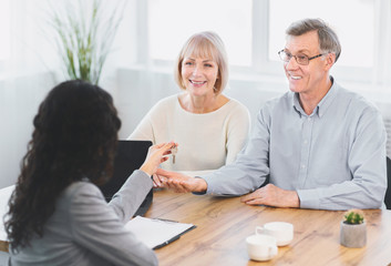 Happy mature couple getting key to their new place