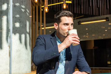 Wall Mural - young businessman sitting at cafe drinking coffee