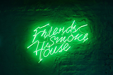 large neon green inscription on a white stone wall