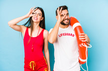 Young Lifeguard Couple Isolated Excited Keeping Ok Gesture On Eye.