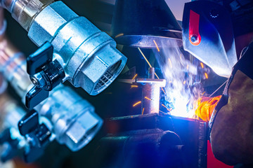 Poster - Welding work in the new house. A man is welding pipes. Vacancies for welders. Training of welders. Work in construction. Repair of the water supply system.