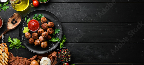 Fotografía Baked Beef Meatballs with Ketchup on a Black Plate