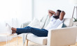 © Prostock-studio - Young african american man relaxing at home, free space