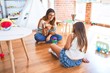 © Krakenimages.com - Beautiful teacher and toddler playing with wooden building blocks around lots of toys at kindergarten