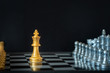 Gold king chess standing on chessboard in front of opponents on dark background with copy space. Business strategy, planning, decision making, and competition concept.