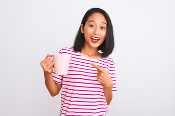 Young beautiful chinese woman drinking cup of coffee over isolated white background very happy pointing with hand and finger