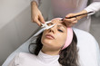 © kiy_lg - Marking eyebrows with a pencil. Permanent makeup, tattooing of eyebrows. Cosmetologist in white gloves applying make up for woman in beauty salon