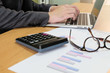 © BritCats Studio - Blurred selective focus, Smart businessman with suit calculate and type on financial, tax and business info graphic graph pie chart. Tax and expense cost saving for personal and enterprise corporate.