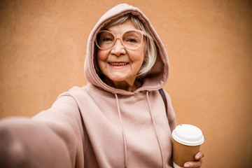 Poster - Funny stylish grandmother taking selfie stock photo