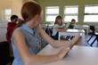 © wavebreak3 - Schoolgirl sitting at a desk using a tablet computer