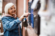 © Yakobchuk Olena - Cheerful elderly lady unlocking letterbox stock photo