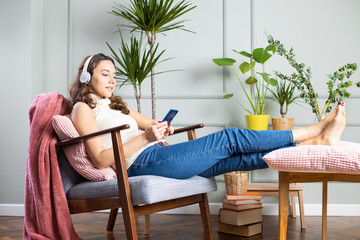 Wall Mural - Young woman listening to music at home