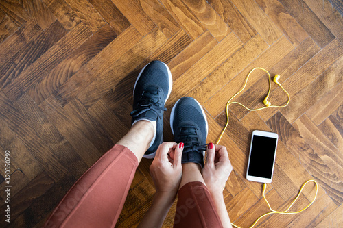 Woman tying shoelace before workout. Tableau sur Toile