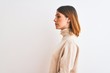 © Krakenimages.com - Beautiful redhead woman wearing winter turtleneck sweater over isolated background looking to side, relax profile pose with natural face with confident smile.