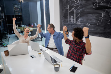 Wall Mural - Happy business colleagues holding hands and laughing