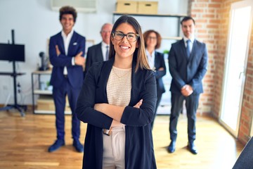 Group of business workers smiling happy and confident in a meeting. Standing with smile on face looking at camera at the office.