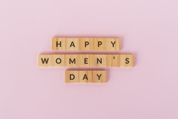Wall Mural - Happy Women's text on wood blocks. Pink background.