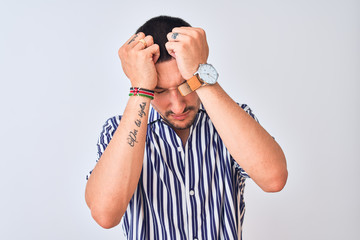 Wall Mural - Young handsome man wearing nautical striped shirt standing over isolated background suffering from headache desperate and stressed because pain and migraine. Hands on head.