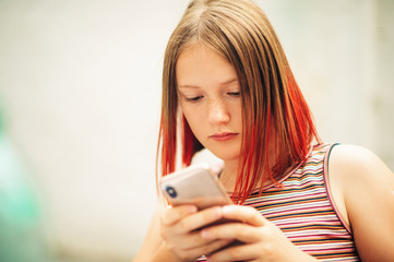 close up portrait of young teenage girl using smart phone