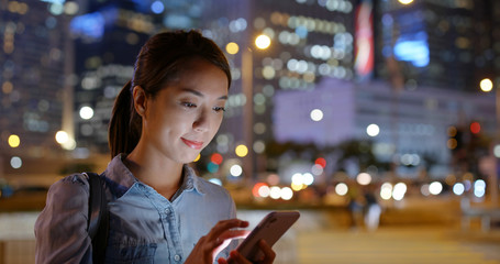 Wall Mural - Woman use mobile phone app for call taxi at night