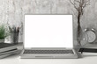 © dimamoroz - Workspace with blank laptop monitor white screen mock up on the white desk near concrete wall. 3d illustration
